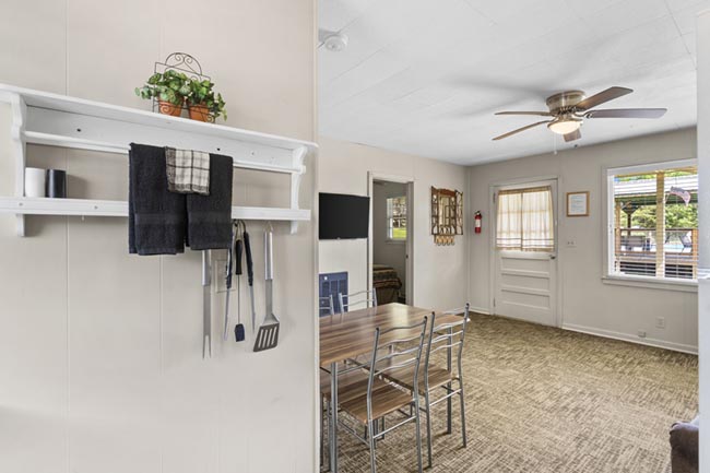 Interior view of a cabin dining area with table, chairs, and ceiling fan